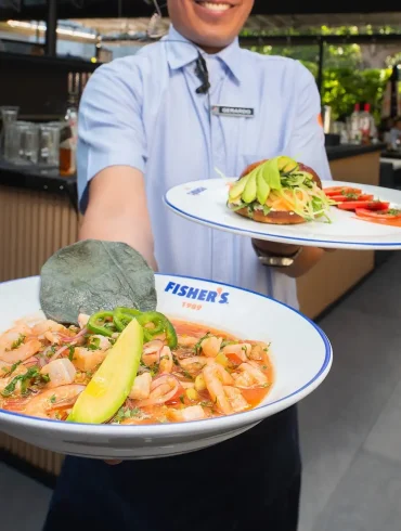 Mesa editorial en Fisher's México mostrando platillos de mariscos frescos y coctelería en una terraza moderna